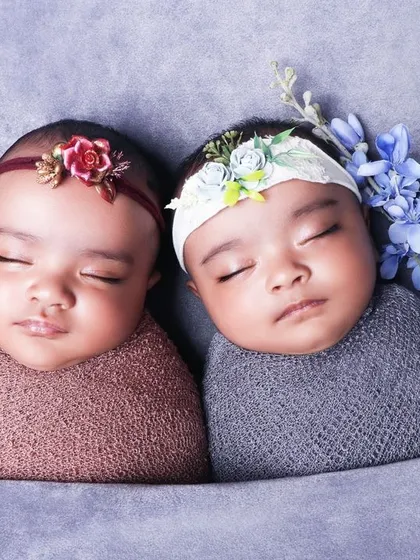A close-up portrait of sleeping newborn twins, swaddled side-by-side. I focus on capturing their peaceful expressions and tiny features in these special twin photoshoots.