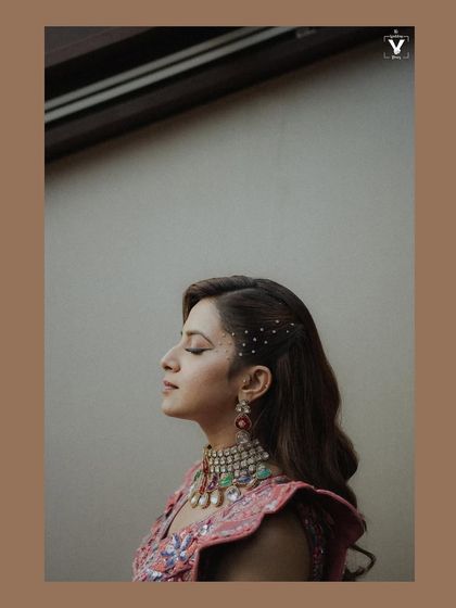 A serene profile shot of the bride with her eyes closed, showcasing her intricate hairstyle and makeup. The soft lighting and her peaceful expression create a moment of calm beauty.
