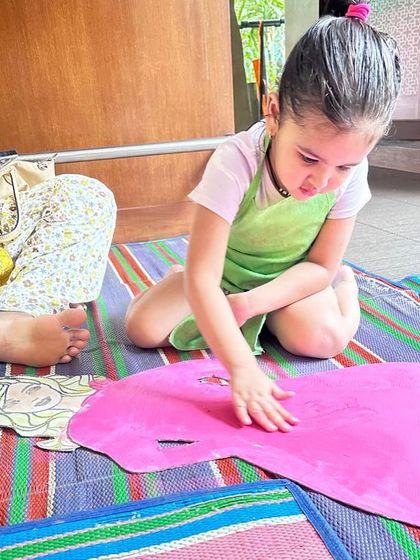 Getting hands-on with our Barbie theme. This child is using her fingers to spread pink paint, fully embracing the messy play philosophy.