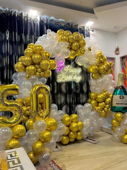 A side view of the milestone birthday setup, showing the foil numbers and champagne balloon.