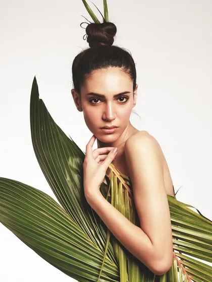 A direct and confident gaze. The minimal makeup and sculpted hair ensure that the focus remains on the unique, nature-inspired styling.