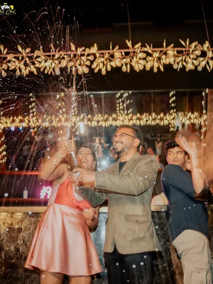 Another angle of the celebration, with friends cheering in the background. It's all about the shared happiness.
