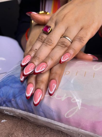 The finished set of red and white double French nails, looking elegant and perfectly shaped.