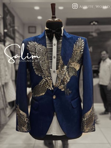 A mannequin displaying a royal blue velvet tuxedo jacket with a stunning gold and silver embroidered eagle. The wings spread across the chest and sleeves for a dramatic effect.