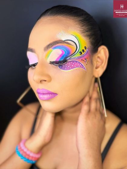 Eyes closed to fully display the intricate design and blending of the colorful, graphic eye makeup.