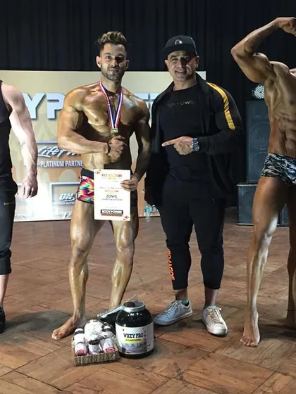 On stage with my winning clients at a Bodypower event. I'm not just a coach who sends you off; I'm there with you, guiding you through the competition day itself.