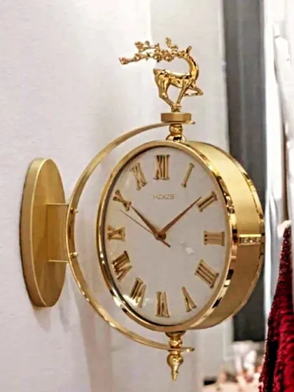 Inspired by classic station clocks, this double-sided wall clock features a vintage Roman numeral face and an ornate deer topper. Its antique gold finish provides a timeless, sophisticated look perfect for hallways or open-plan living areas.