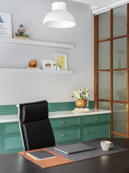 A well-designed workspace inspires productivity and calm. This executive cabin, with its clean lines, soothing green cabinetry, and warm wood partitions, demonstrates our approach to creating functional yet aesthetically pleasing office interiors.