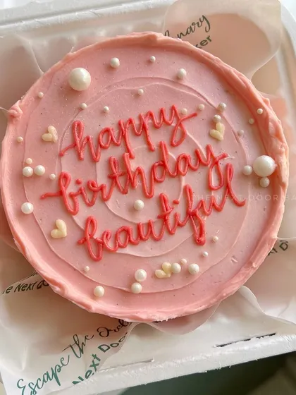 A simple and sweet mini cake with a heartfelt message. The soft pink buttercream and pearl sprinkles make this "happy birthday beautiful" cake a lovely personal gift.
