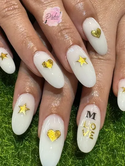 A lovely design with milky white nails, gold stars, and hearts, and the word "LOVE".