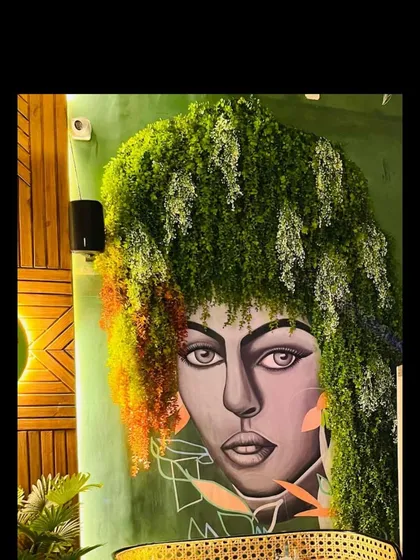 A creative fusion of art and nature, where we used hanging greenery to form the 'hair' for a large mural in a cafe.