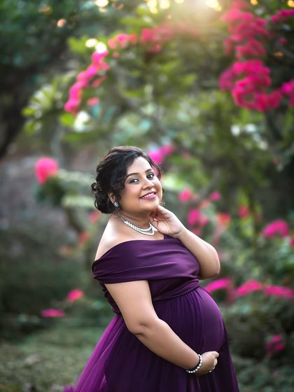 A classic and elegant solo portrait of the mother-to-be, framed by beautiful bougainvillea flowers.