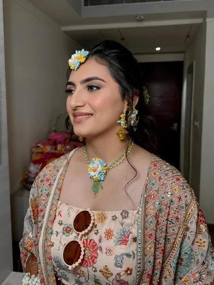 My beautiful Haldi bride, Palak. Her look is fresh and vibrant, with a touch of blue on the eyes to match her floral jewelry. A perfect look for a sunny, happy day.