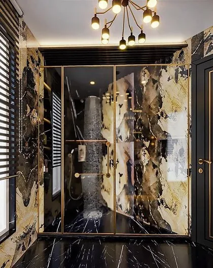 A full view of the guest bathroom with Patagonia marble. This angle shows the glass shower enclosure and the dramatic, continuous pattern of the stone.