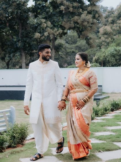 A candid shot of the couple taking a stroll, hand in hand, at their wedding venue. Their relaxed smiles and traditional attire make for a beautiful, natural portrait.