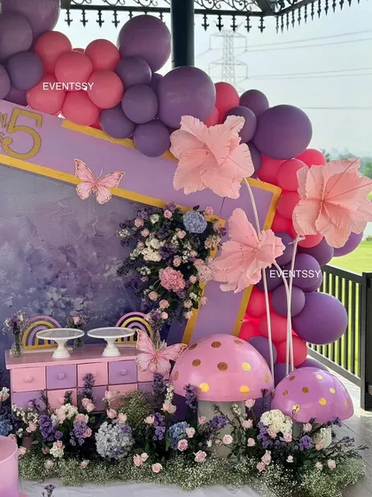 A side view of the enchanting floral setup, showing the depth of the decor with its layered props and balloon arrangements.