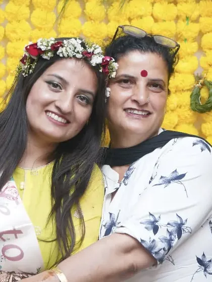 A sweet moment between the bride and a family member, posing against a wall of marigolds. Capturing these family connections is a key part of my event photography.