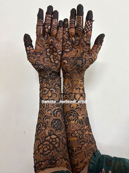 This design shows a beautiful combination of checkerboard patterns on the fingers and dense floral work on the rest of the hands.