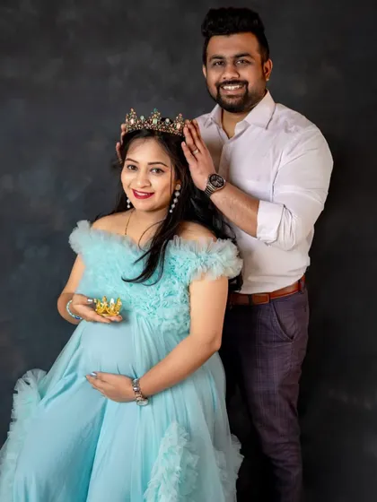 A fun and royal-themed maternity shoot. The couple uses crowns to add a playful touch, with the mom-to-be looking radiant in a light blue off-shoulder gown.