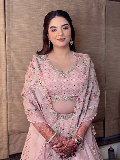 A smiling portrait of Esha. Her makeup enhances her natural beauty, making her look radiant and confident for her special day.