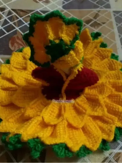 A vibrant sunflower-themed poshak for Kanha ji, handcrafted with soft yellow, green, and red wool. The layered petals create a full, beautiful silhouette, and the design includes a matching cap.