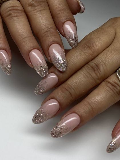 A glamorous set of long, almond-shaped extensions with a sparkling champagne glitter ombré. This look is perfect for any festive occasion.