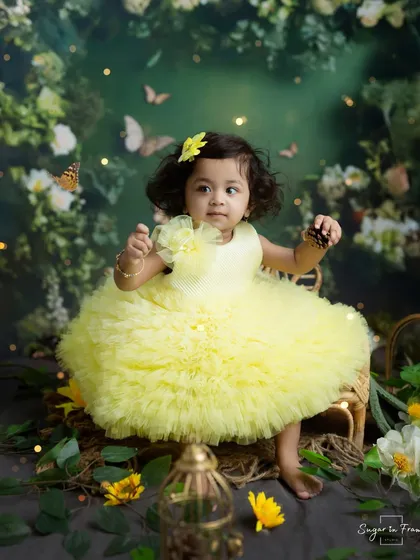 A little ray of sunshine in her yellow dress, this fairy is sitting in an enchanted garden filled with flowers and butterflies.