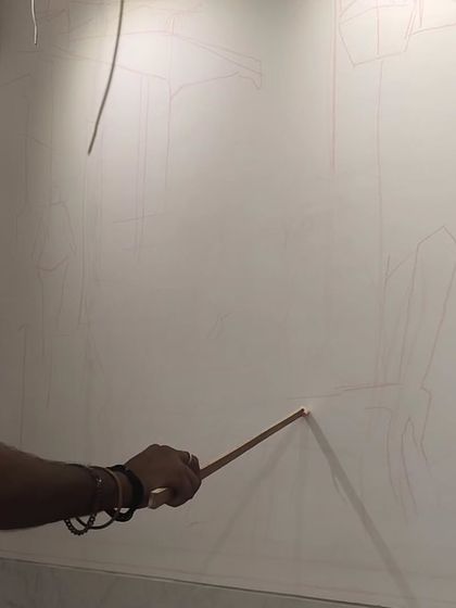 A close-up showing my hand as I draw the initial fine lines for the composition directly onto the wall. Precision at this early stage ensures the final painting has a solid structural foundation.