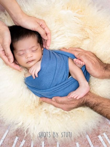 The hands of the parents surround their precious rainbow baby, a symbol of their love and protection after a challenging journey. This is a story of hope fulfilled.