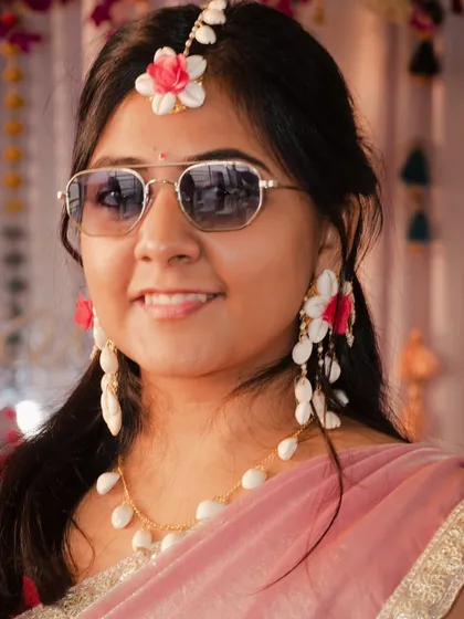 The cool bride. A fun portrait from the Haldi ceremony where the bride is wearing sunglasses, showing her playful personality amidst the traditional festivities.