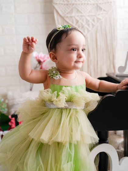 Mamma's little sunshine. This beautiful girl in her green dress is captured in a moment of pure, angelic sweetness during her first birthday shoot.