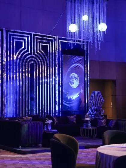 Another angle of the modern lounge, showing the interplay of the geometric mirrored panels and the cosmic moon prints.