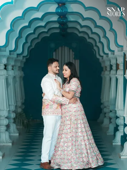 An intimate portrait of the couple within a stunning blue arched hallway. The symmetry and color create a visually captivating pre-wedding photograph.