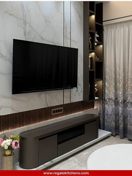 A sophisticated design with a marble accent wall and curved wood paneling. The floating console and lit display cabinet add to the high-end feel.
