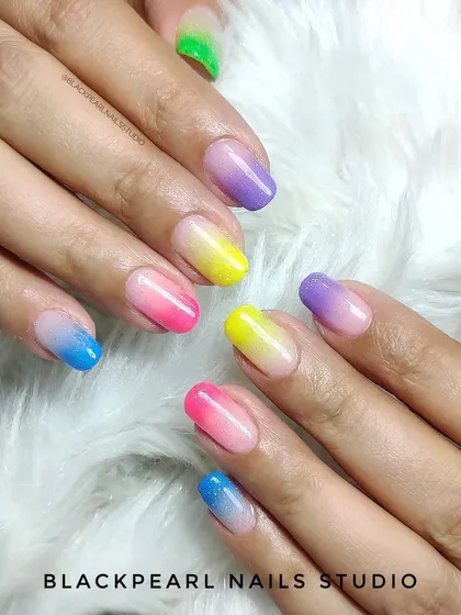 A playful and vibrant set of "candy nails" featuring a multi-color neon ombré. Each nail has a different gradient, creating a fun and eye-catching look that is perfect for making a statement.
