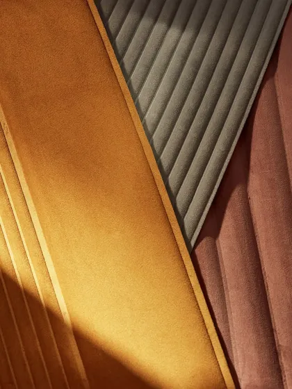 A composition of our ribbed, 3D wallcoverings in different colors. The play of light across the sculpted surfaces highlights the architectural elegance and velvety texture of the designs.