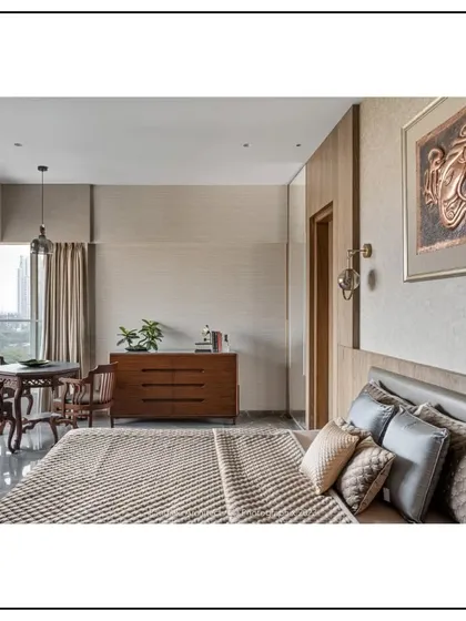 Natural light floods this bedroom, which features a cozy seating nook perfect for reading. The design connects the indoor space with the outdoors through a large window, enhancing the room's tranquil feel.