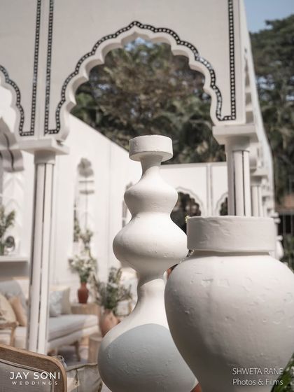 The sculptural white vases were a key element in the ivory wedding decor, adding a modern artistic touch that contrasted beautifully with the traditional arches.