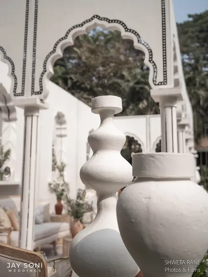 Sculptural white vases add a modern, artistic touch to the classic, traditional architecture of the lounge pavilion.