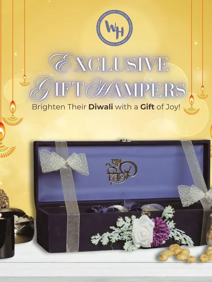 An exclusive gift hamper for a bright Diwali. This long, elegant purple box is tied with silver ribbons and contains gourmet popcorn and other treats, accompanied by a black decorative candle.