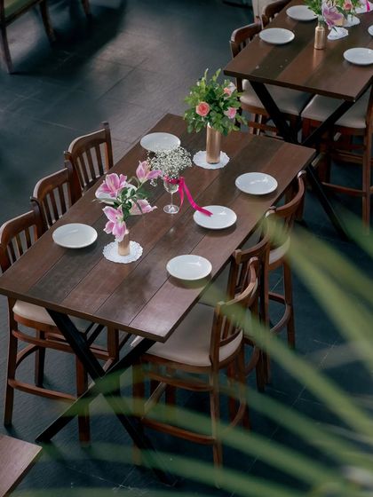 A table set for a gathering, adorned with fresh flowers. This is where stories are shared and new friendships are forged.