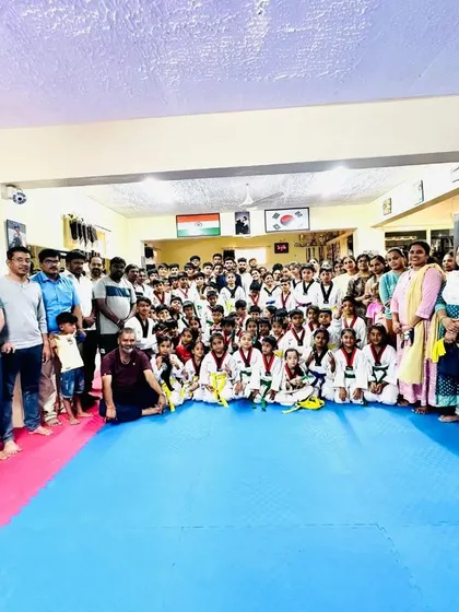 Students, coaches, and proud parents gather for a photo after a successful belt promotion ceremony.