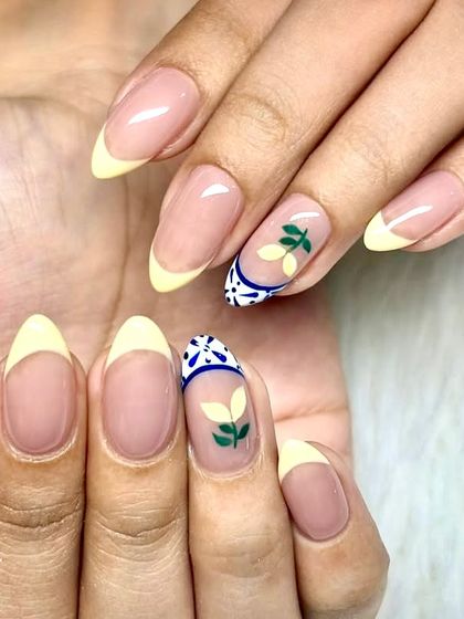 When life gives you lemons, get them on your nails. A juicy twist on French tips with pastel yellow, leafy green sprigs, and a ceramic tile-inspired accent nail.