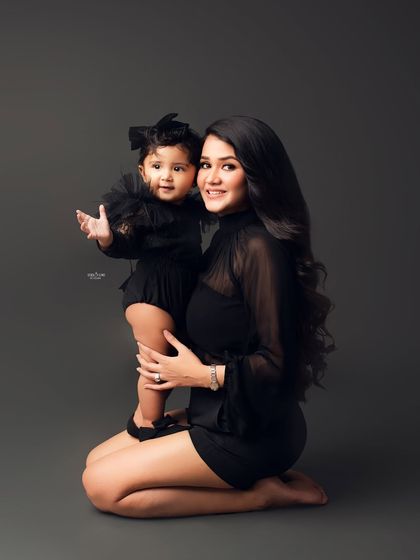A sweet and stylish portrait of a mother and her daughter in matching black outfits.