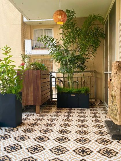 On the other side of the Palm Springs balcony, we placed a custom wooden cabinet for storage and display. It’s flanked by tall planters that add height and greenery, balancing the overall design of the space.