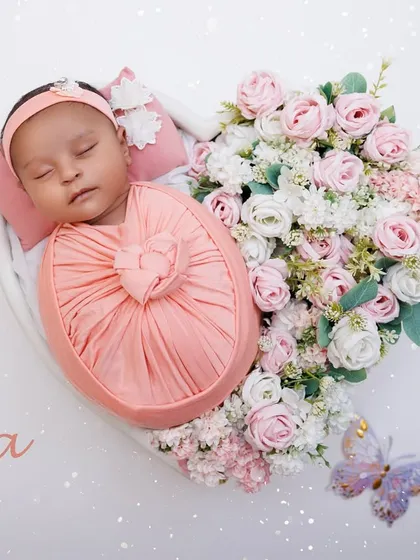 A personalized portrait of baby Ira, sleeping in a heart-shaped bowl filled with pink and white roses.
