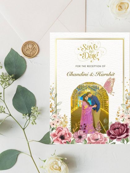 A Save the Date that feels like a fairytale. This design for Chandini and Harshit features their custom illustration inside a beautifully lit archway, surrounded by a cascade of romantic flowers.