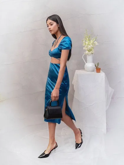 A dynamic walking shot from the Sarjaa campaign. This image shows the movement of the clothing and how the small black handbag complements a stylish, modern look.