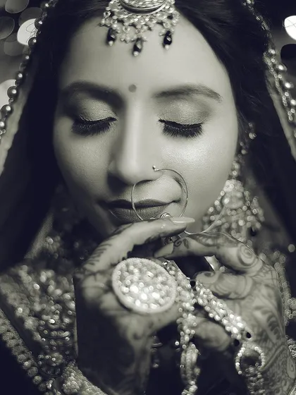 A timeless black and white close-up, emphasizing the emotion and the intricate details of the henna and jewelry.