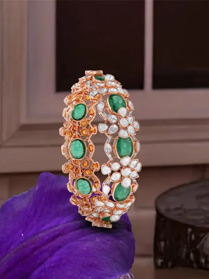 Emerald whispers and diamond lights come together in this exquisite bridal kada. The combination of green emeralds and uncut Polki diamonds creates a statement of brilliance and heritage.
